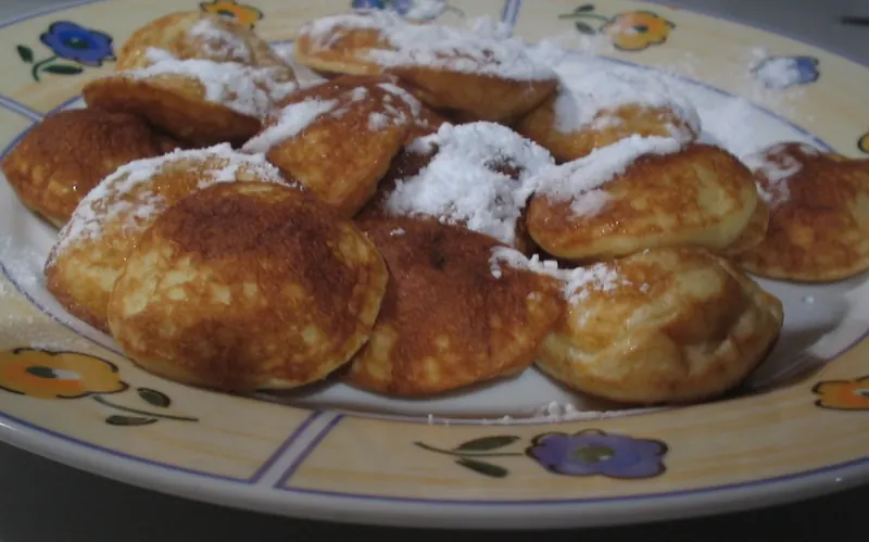 Poffertjes, small fluffy Dutch pancakes, dusted with powdered sugar