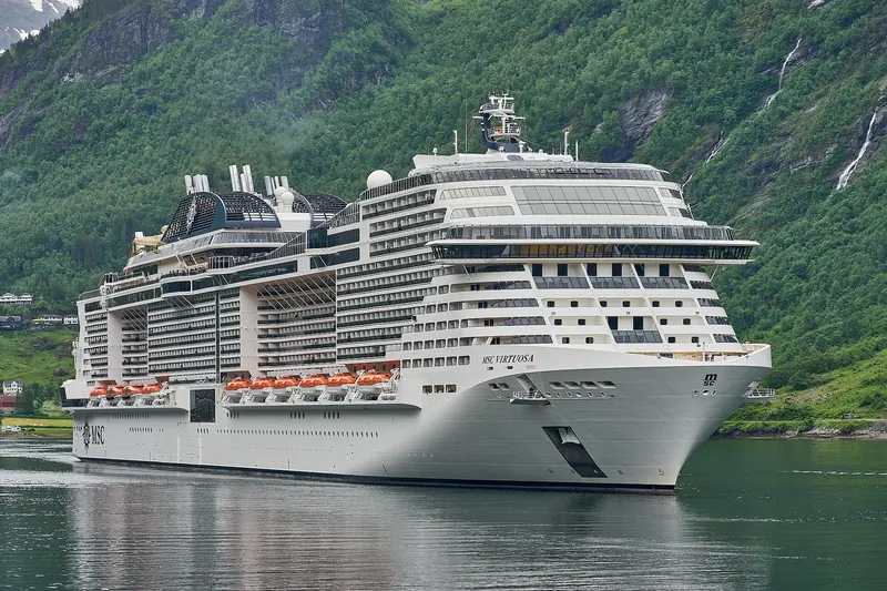 A cruise ship passing close to the cliffs in Geirangerfjord