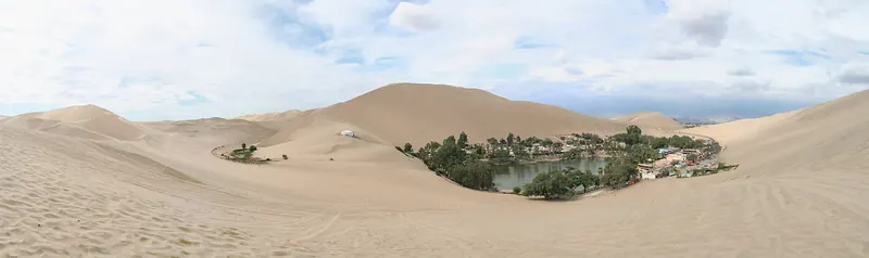Towering sand dunes surrounding the Huacachina oasis