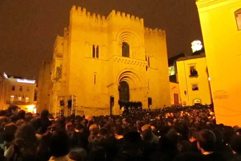 A night-time serenata crowd gathered before the Sé Velha during Coimbra's Queima das Fitas festival