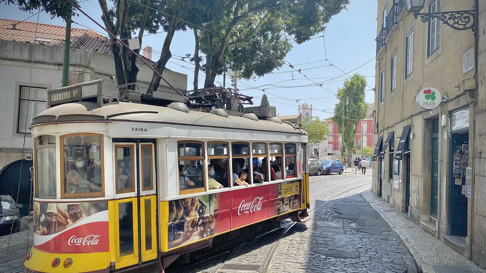 A traditional yellow tram climbing through Lisbon's Alfama district