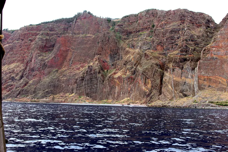The sheer red-rock face of Cabo Girão, one of Europe's highest sea cliffs, seen from the water