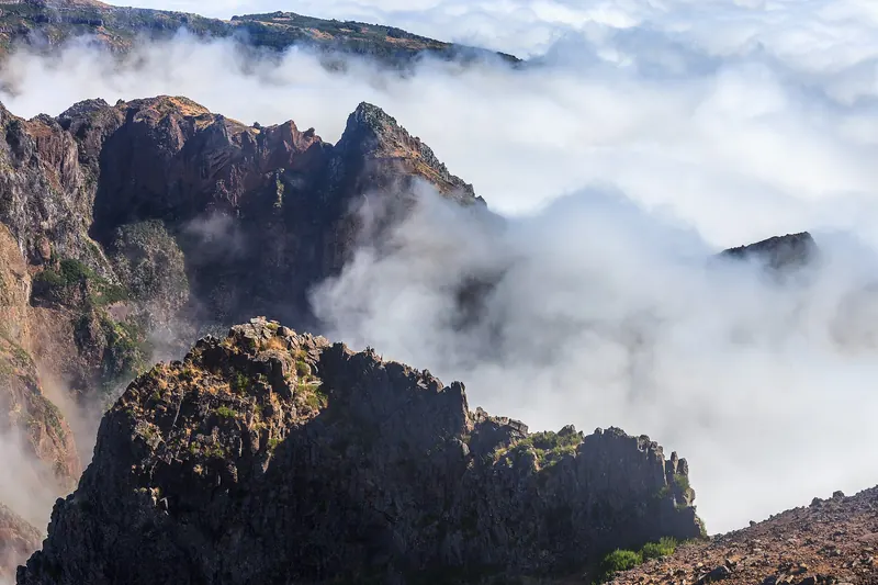 The rocky summit of Pico do Arieiro rising above a sea of clouds in Madeira's central mountains