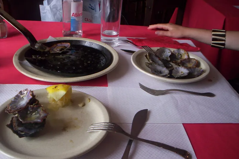 Lapas, grilled limpets served in their shells with garlic butter
