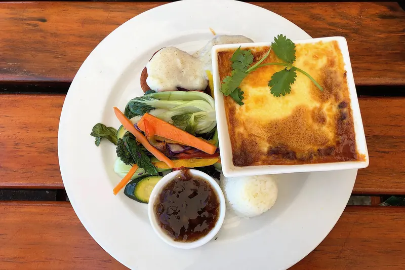 A serving of bobotie, spiced minced meat baked with an egg topping