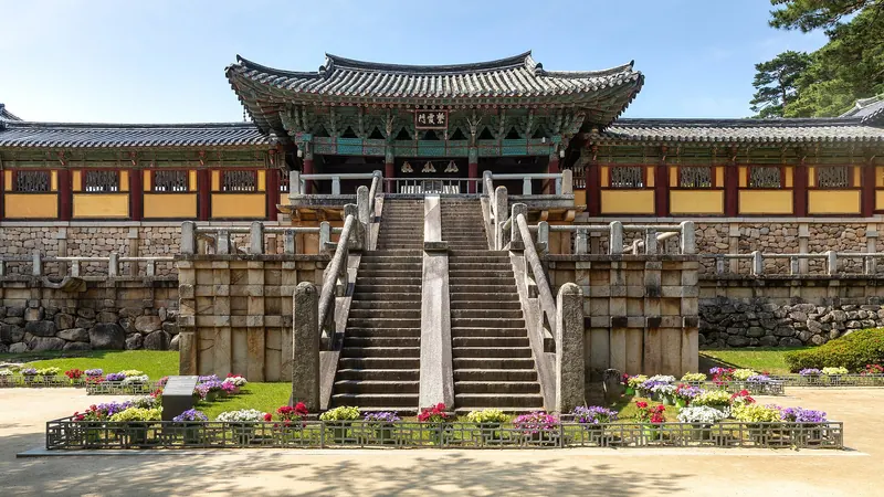 The stairs and entrance gate of Bulguksa temple with a flower bed and blue sky