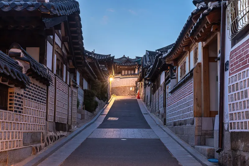 Traditional hanok houses lining a hillside street in Bukchon at blue hour