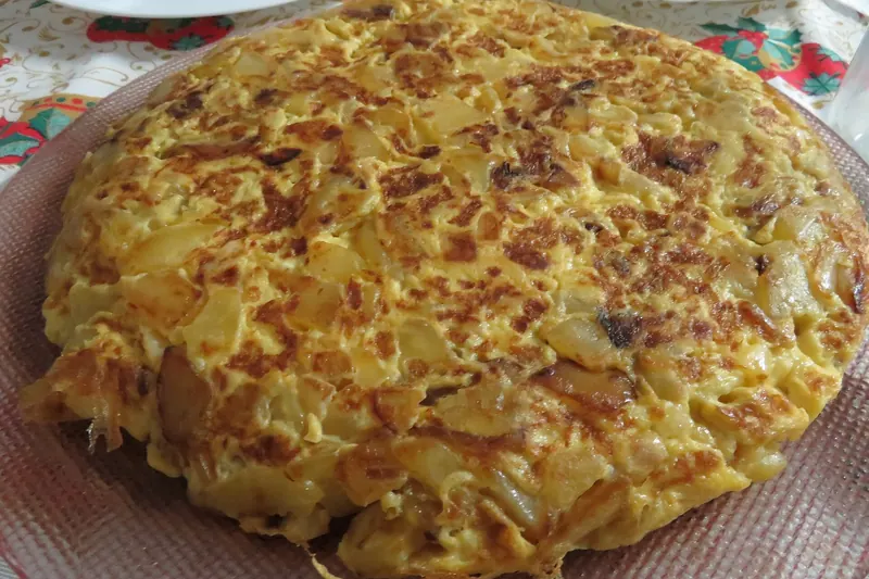 A thick potato and onion tortilla cut into wedges