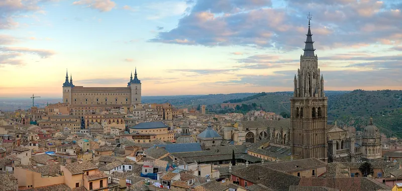 The stacked skyline of Toledo above the Tagus river at dusk