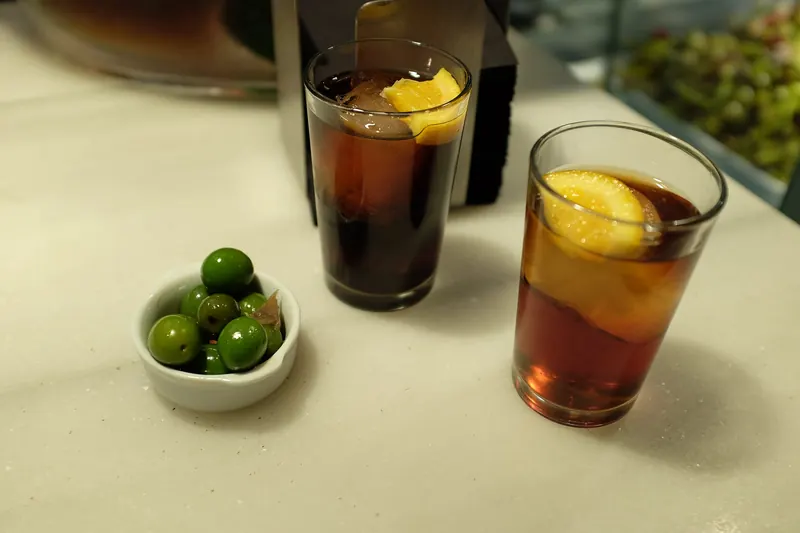 Vermut served on ice with orange and a bowl of olives
