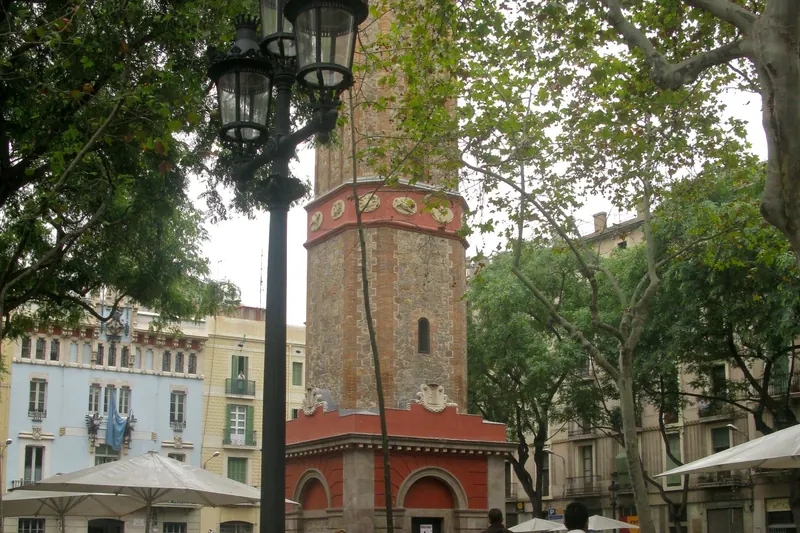 The clock tower and terrace cafés on a square in Gràcia