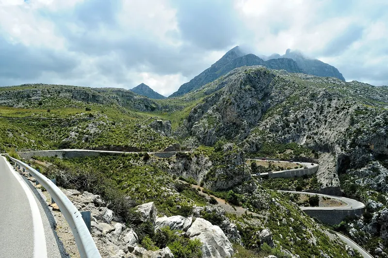 Terraced slopes and pine-covered ridges of the Serra de Tramuntana falling towards the sea in Mallorca