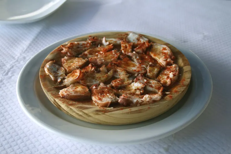 Galician octopus with paprika on a wooden plate