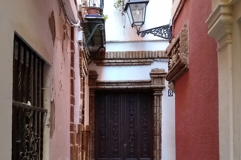 A narrow whitewashed lane in the Barrio Santa Cruz