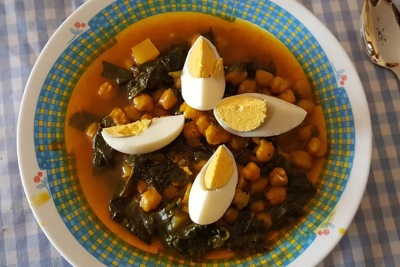 Chickpeas stewed with spinach and topped with boiled egg