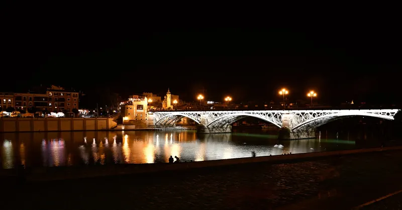 The Puente de Isabel II lit at night over the Guadalquivir