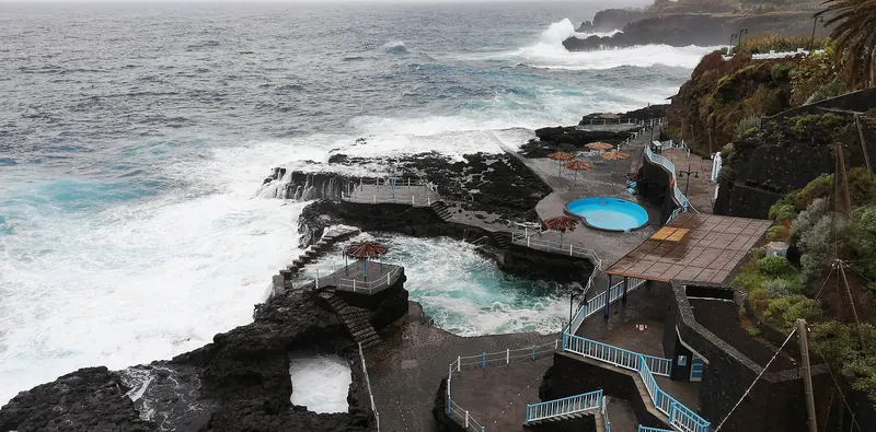 Waves breaking into a natural volcanic rock pool