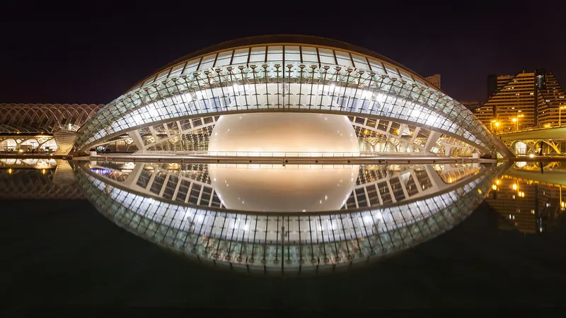 The eye-shaped Hemisfèric building reflected in a pool at the City of Arts and Sciences in Valencia