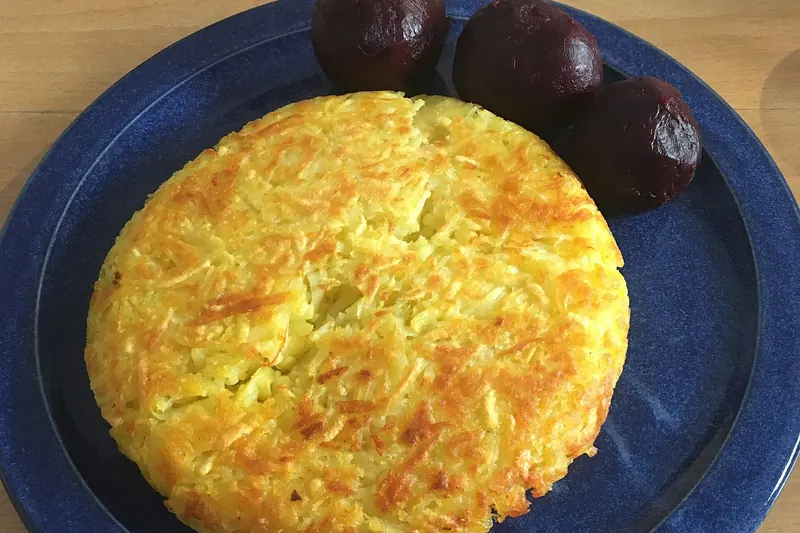 A golden pan-fried potato rösti on a plate