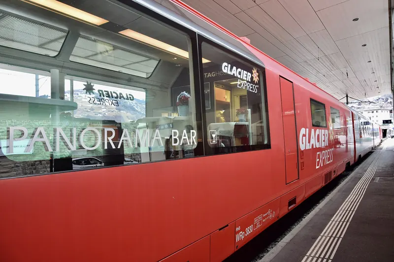 The red Glacier Express train crossing an Alpine valley