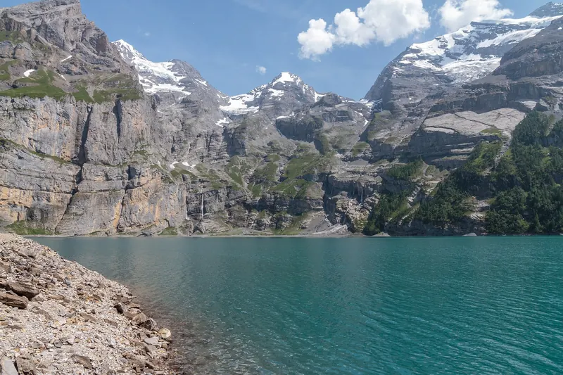 The turquoise Oeschinensee lake surrounded by steep Alpine peaks near Kandersteg