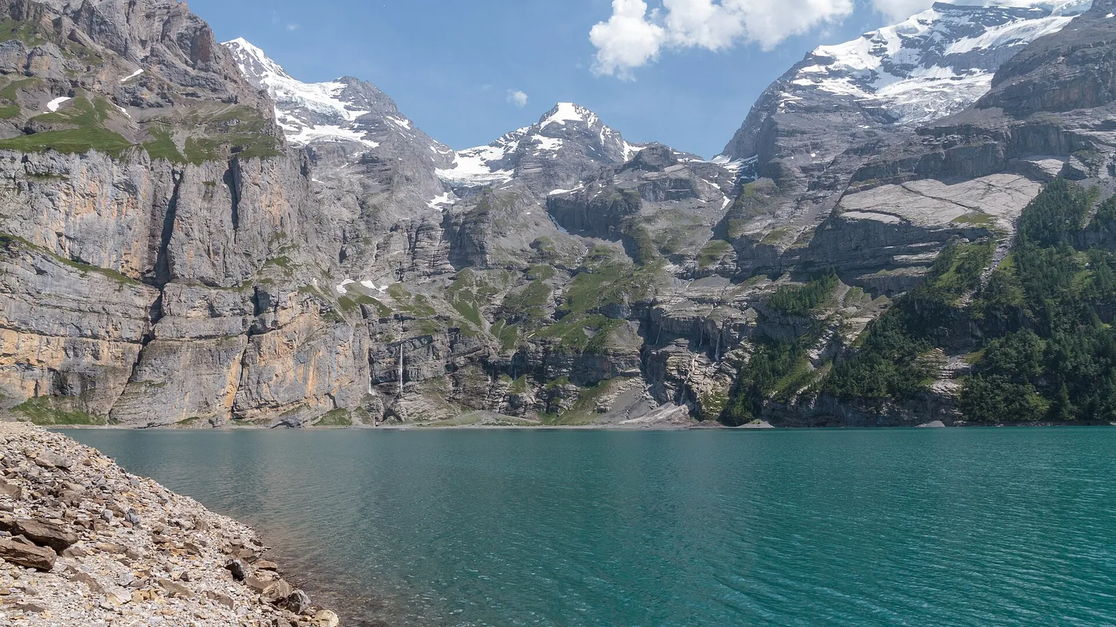 The turquoise Oeschinensee lake surrounded by steep Alpine peaks near Kandersteg