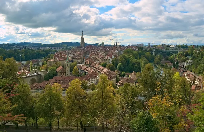 The old town of Bern with red roofs and the cathedral spire, seen from the Rosengarten