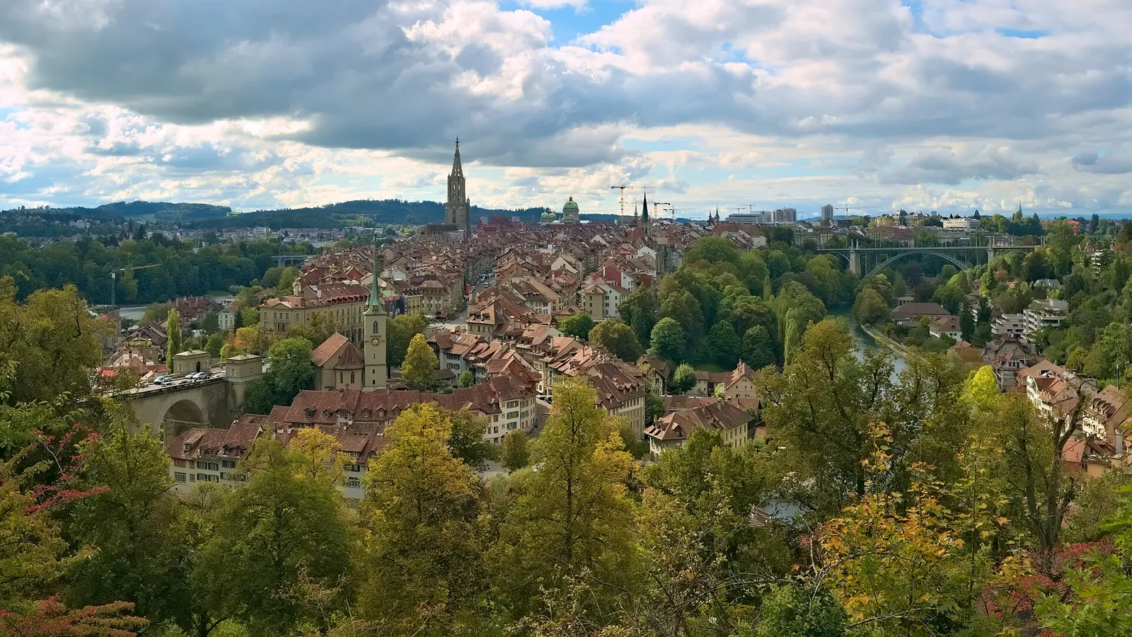 The old town of Bern with red roofs and the cathedral spire, seen from the Rosengarten