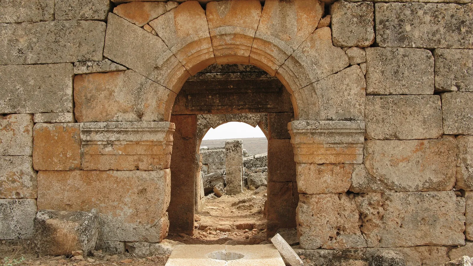 A ruined stone gateway in the abandoned Byzantine village of Serjilla, photographed in 2008, before the war