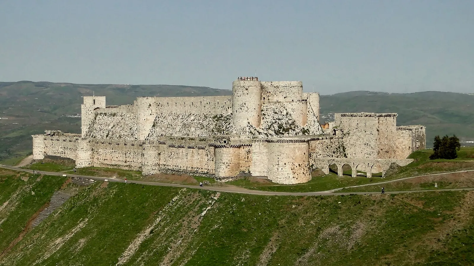 The walls and towers of Krak des Chevaliers on its hilltop, photographed in 2010, before the war
