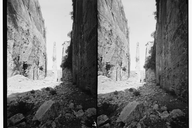 A historic photograph of the tall stone needle in the rock-cut moat that once carried the drawbridge at Saladin's Castle