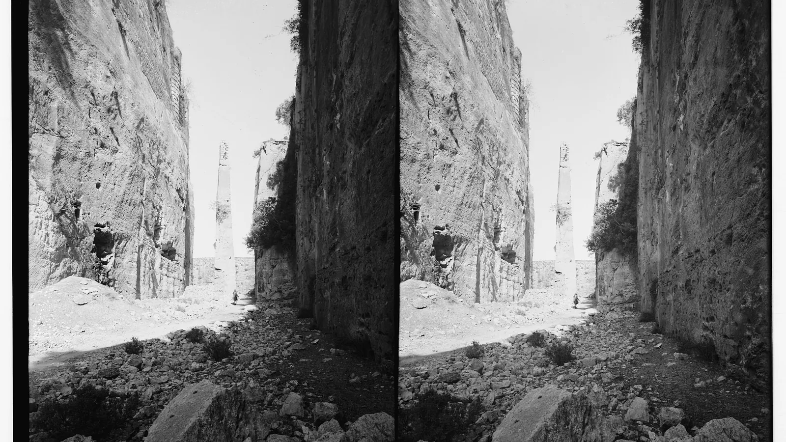 A historic photograph of the tall stone needle in the rock-cut moat that once carried the drawbridge at Saladin's Castle