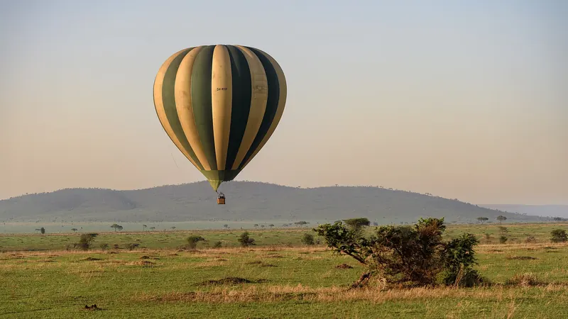 A hot-air balloon rising over the Serengeti plains at dawn
