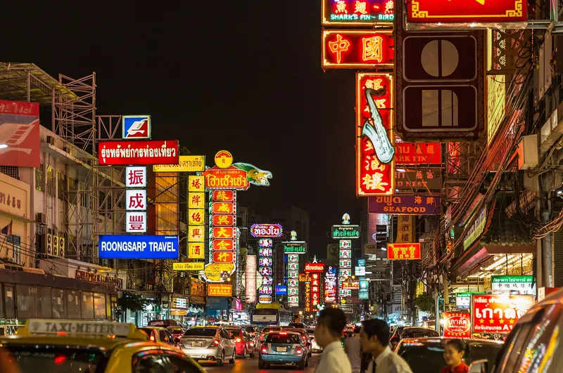 Neon signs and street food stalls along Yaowarat Road in Bangkok's Chinatown at night