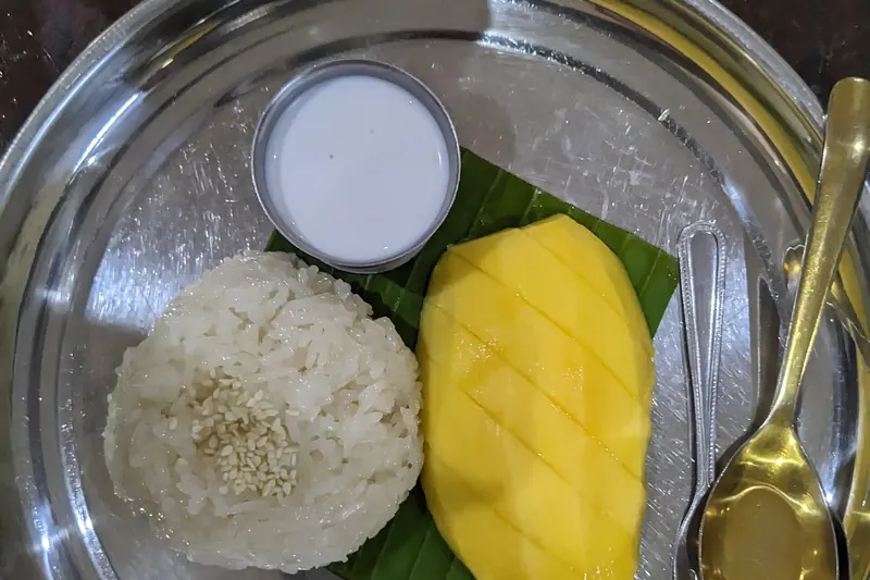 A plate of mango sticky rice with coconut cream