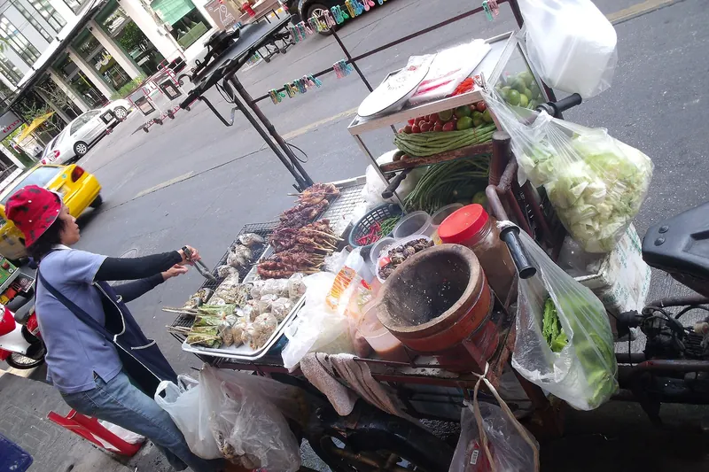 A street food vendor cooking at a stall in Bangkok