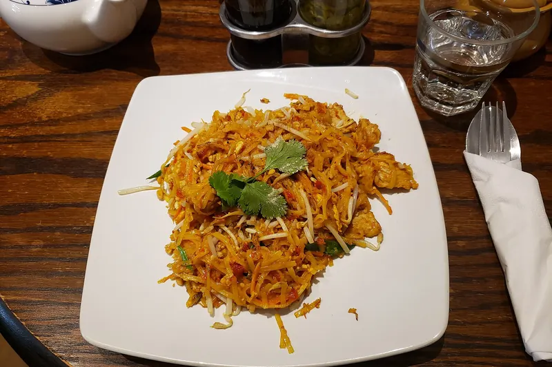 A plate of pad thai with pork