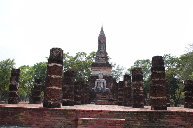 The lotus-bud chedi and Buddha statues of Wat Mahathat in Sukhothai Historical Park