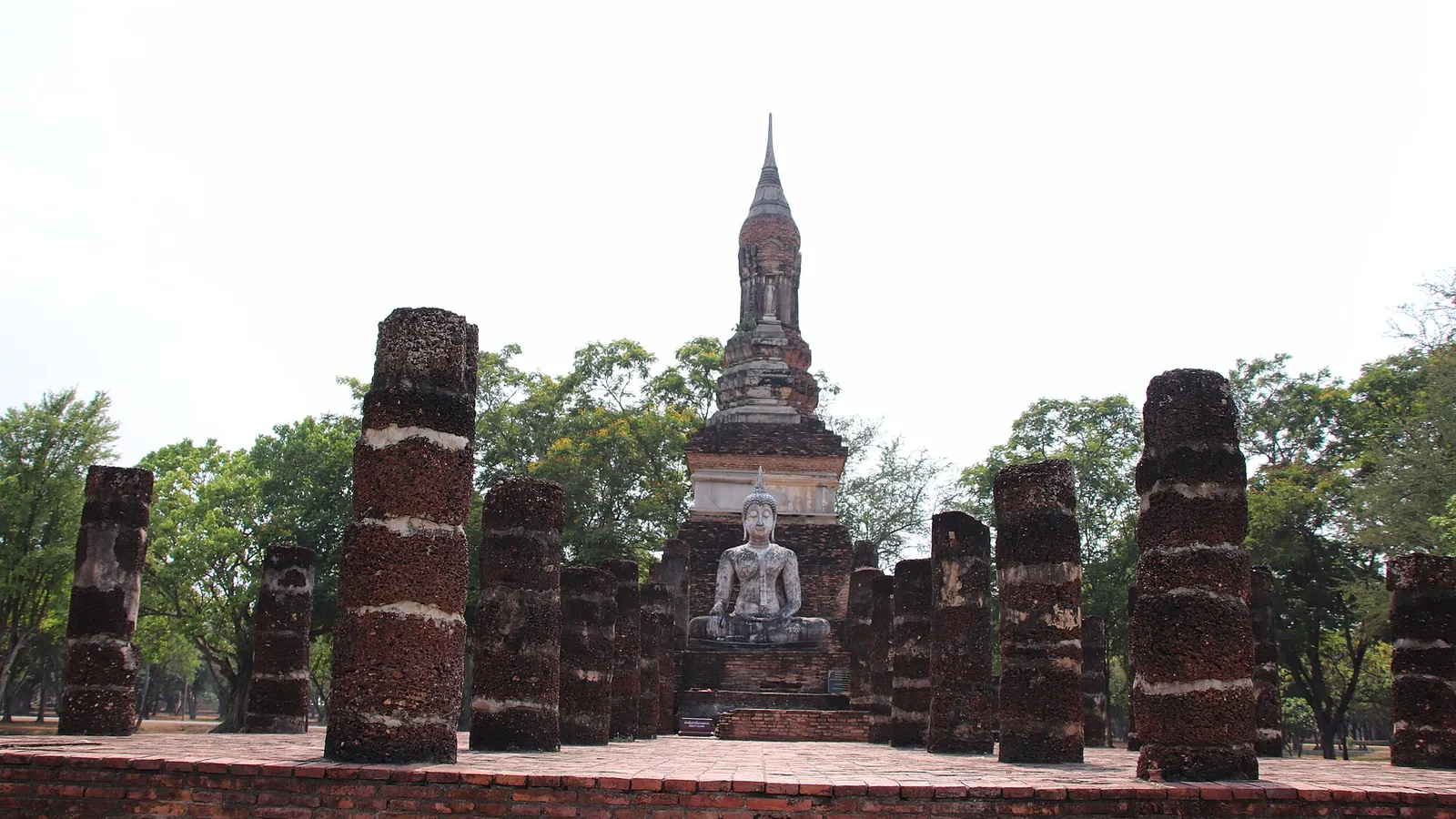 The lotus-bud chedi and Buddha statues of Wat Mahathat in Sukhothai Historical Park