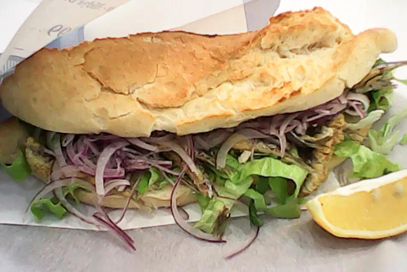 Grilled fish served in bread with onion and rocket
