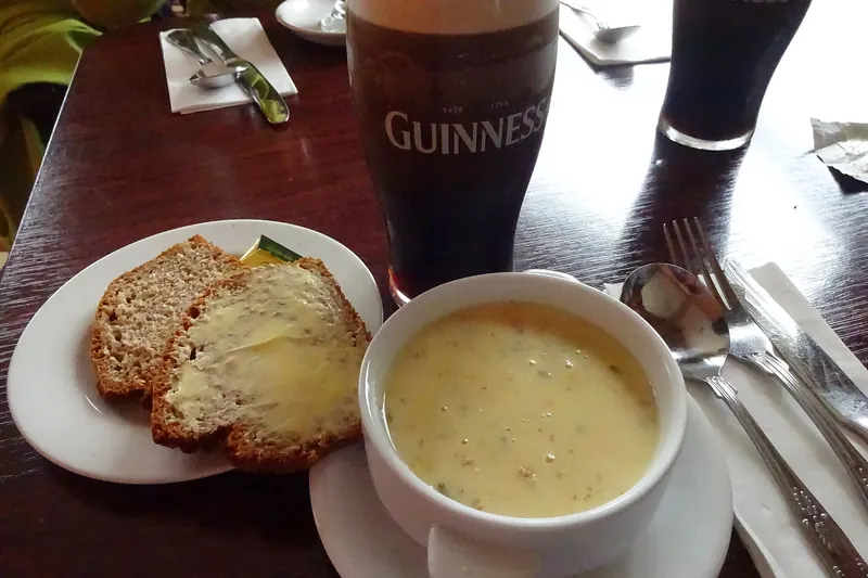 A bowl of seafood chowder with bread