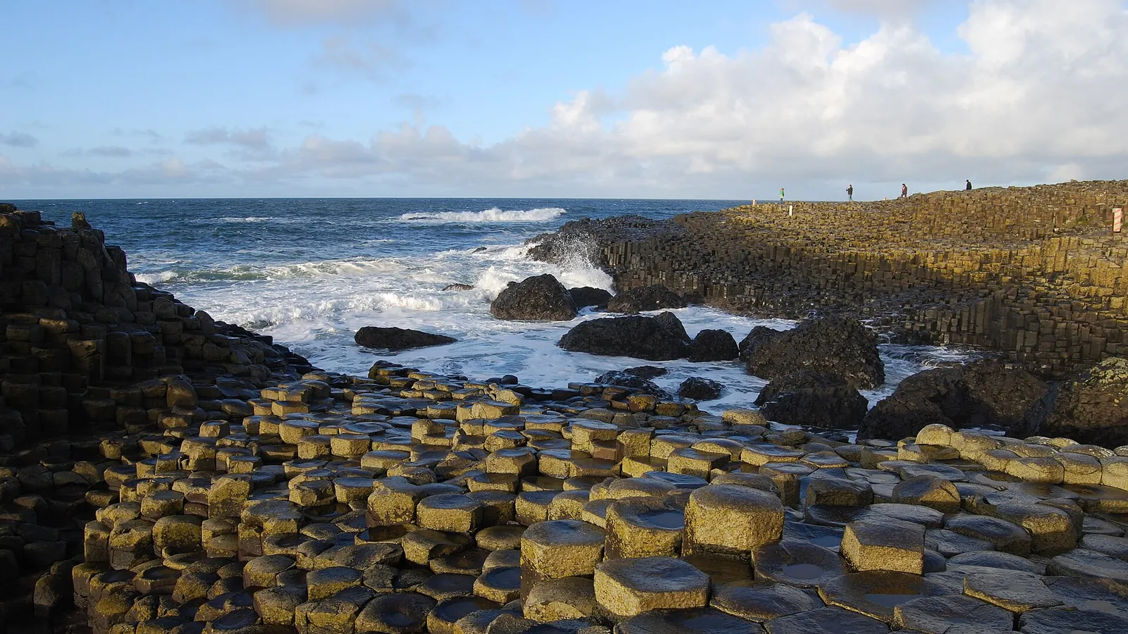 The hexagonal basalt columns of the Giant's Causeway meeting the sea