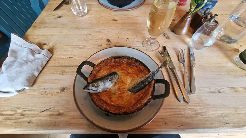 A traditional stargazy pie with fish heads poking through the crust