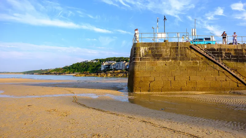 St Ives harbour beach with the pier and town beyond