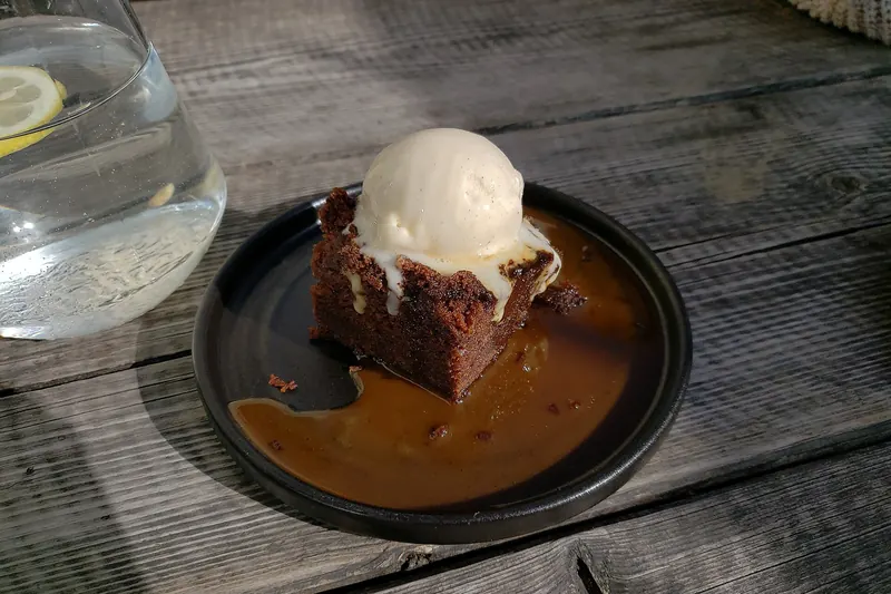 A plated sticky toffee pudding with toffee sauce