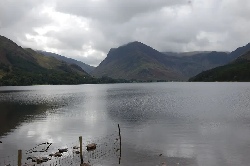 The still water of Buttermere framed by surrounding fells