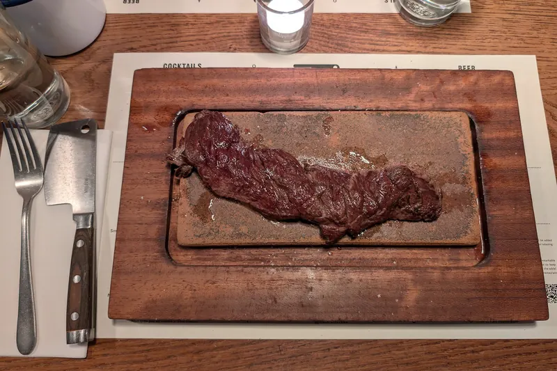A cooked Scottish bavette steak served on a wooden board