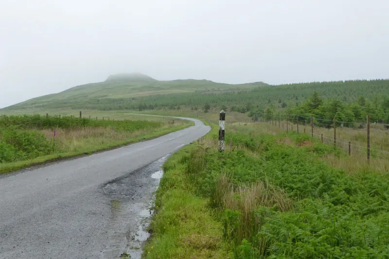 A single-track Highland road with a passing-place marker post