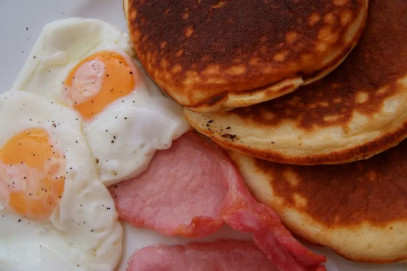 Pancakes, eggs and hash browns on an American breakfast plate