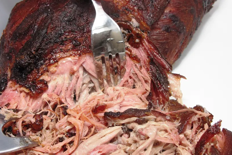 Whole-hog pork being pulled for Carolina barbecue